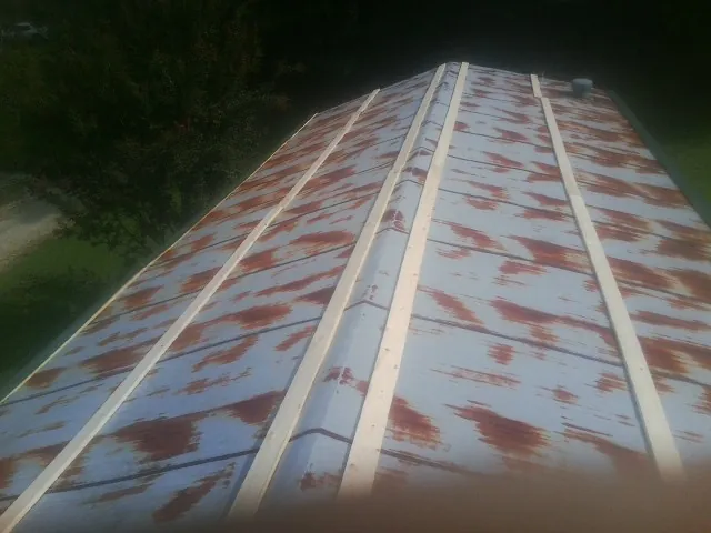 Rusted metal roof panels with new wood purlins before replacement — Storm Damage Roof Repair in Polk by Roofing Brothers